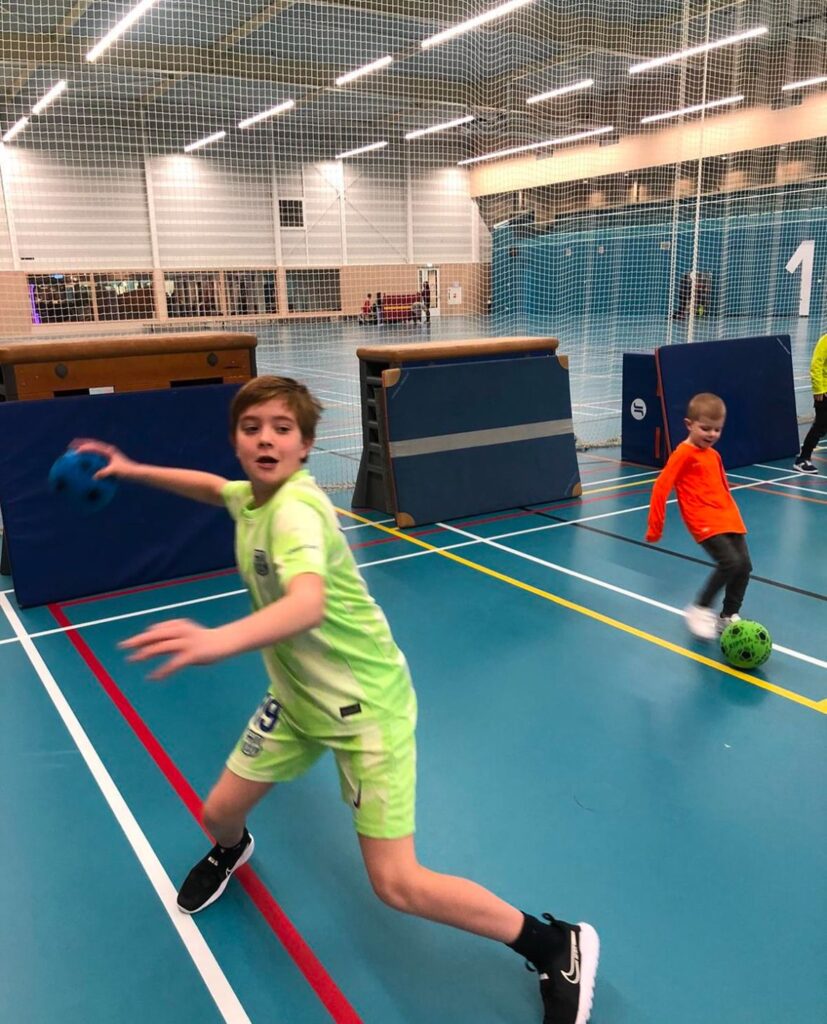 Kind gooit bal bij Sport-BSO Flekss