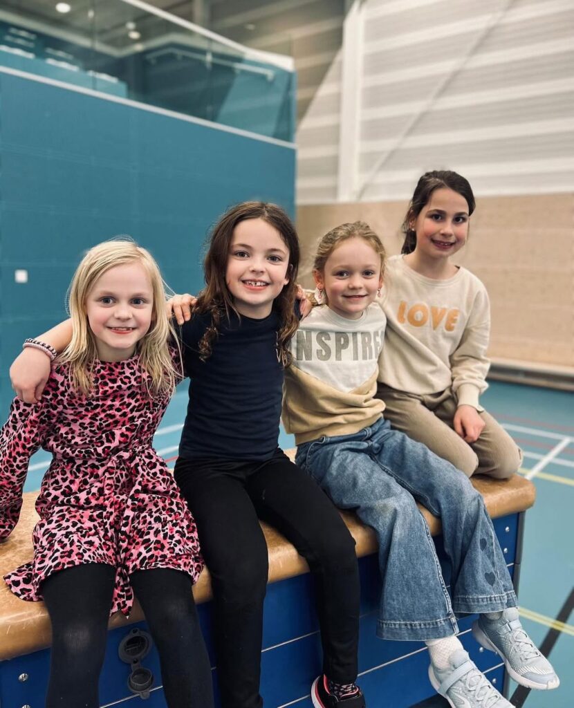 Kinderen zitten op een kast bij Sport-BSO Flekss