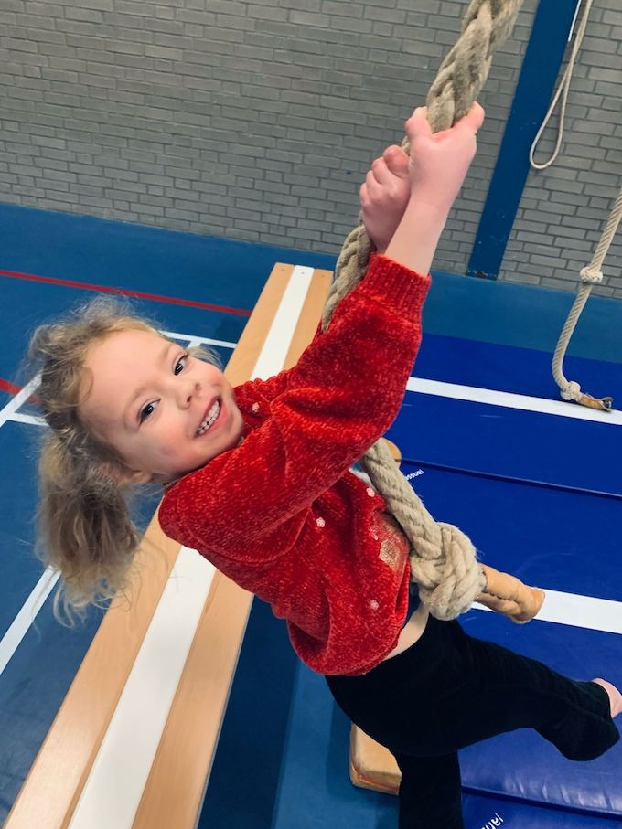 Kind zwaait aan touw bij Sport-BSO Flekss