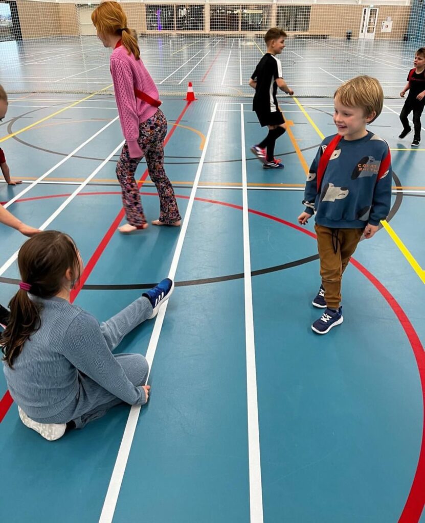 Kinderen spelen tikkertje bij Sport-BSO Flekss