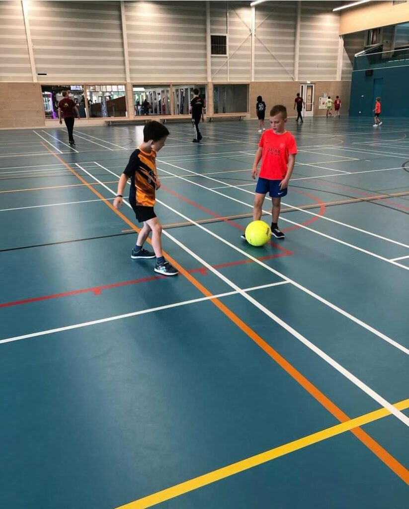 Kinderen voetballen bij Sport-BSO Flekss