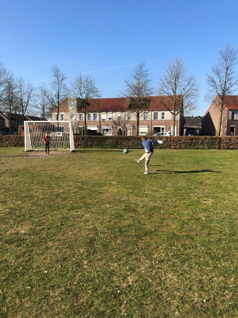 Kinderen voetballen buiten bij Sport-BSO Flekss