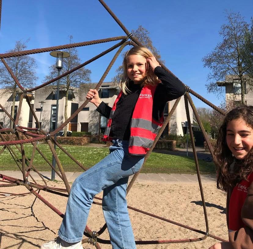 Kinderen klimmen in de speeltuin bij Sport-BSO Flekss