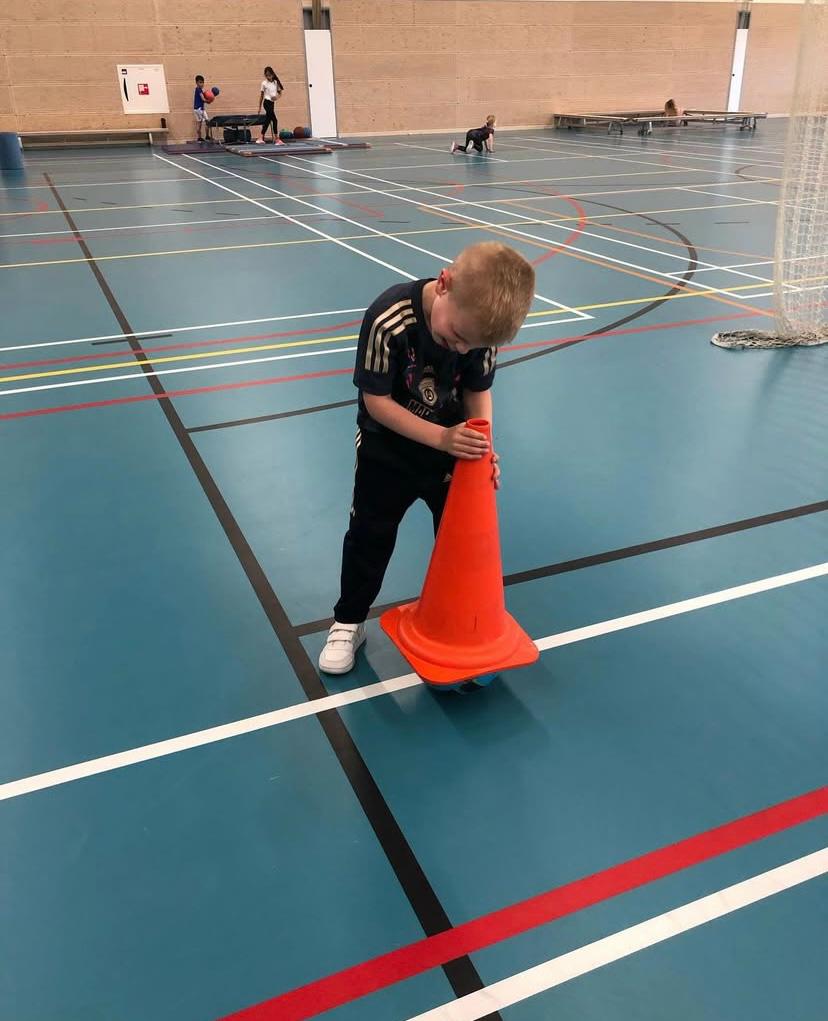 Kind speelt in de gymzaal bij Sport-BSO Flekss
