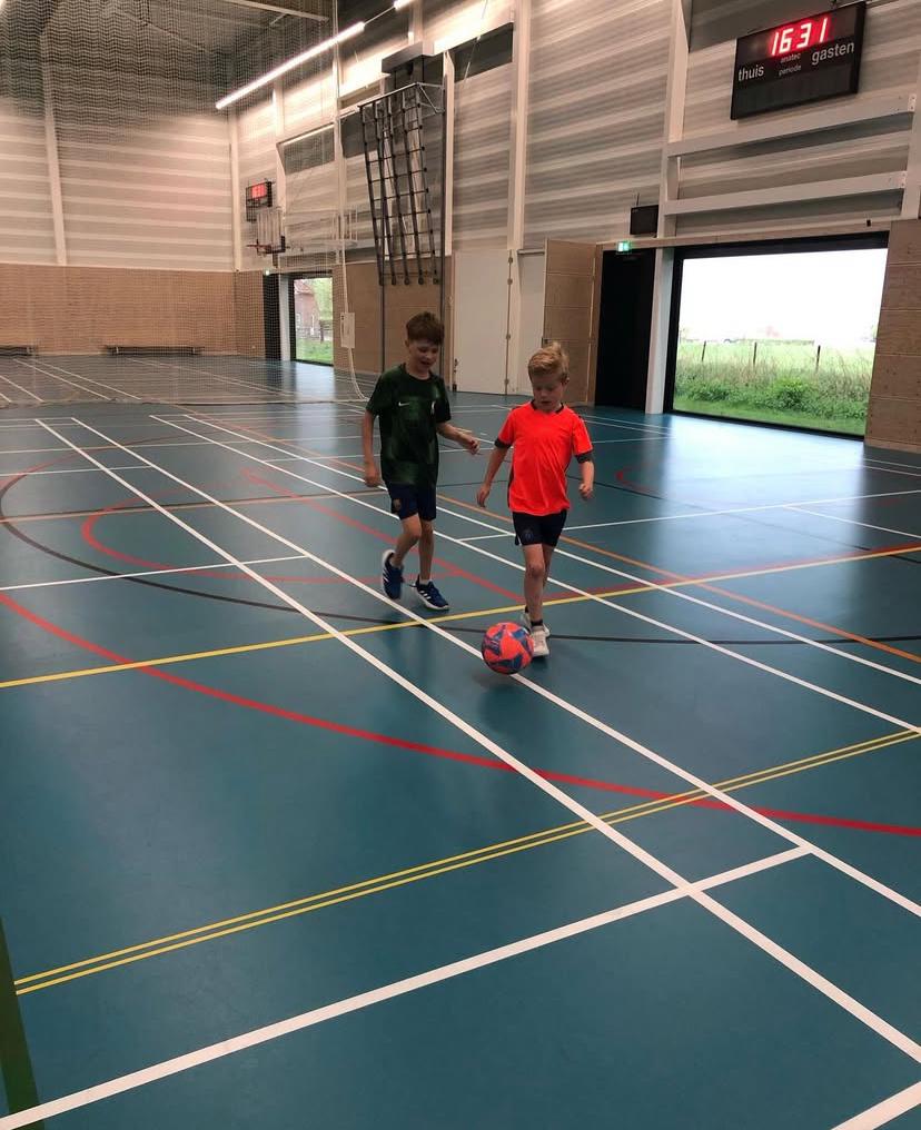 Kinderen voetballen bij Sport-BSO Flekss