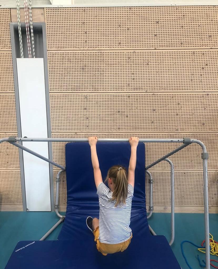 Kind maakt borstwaartsom op de rekstok