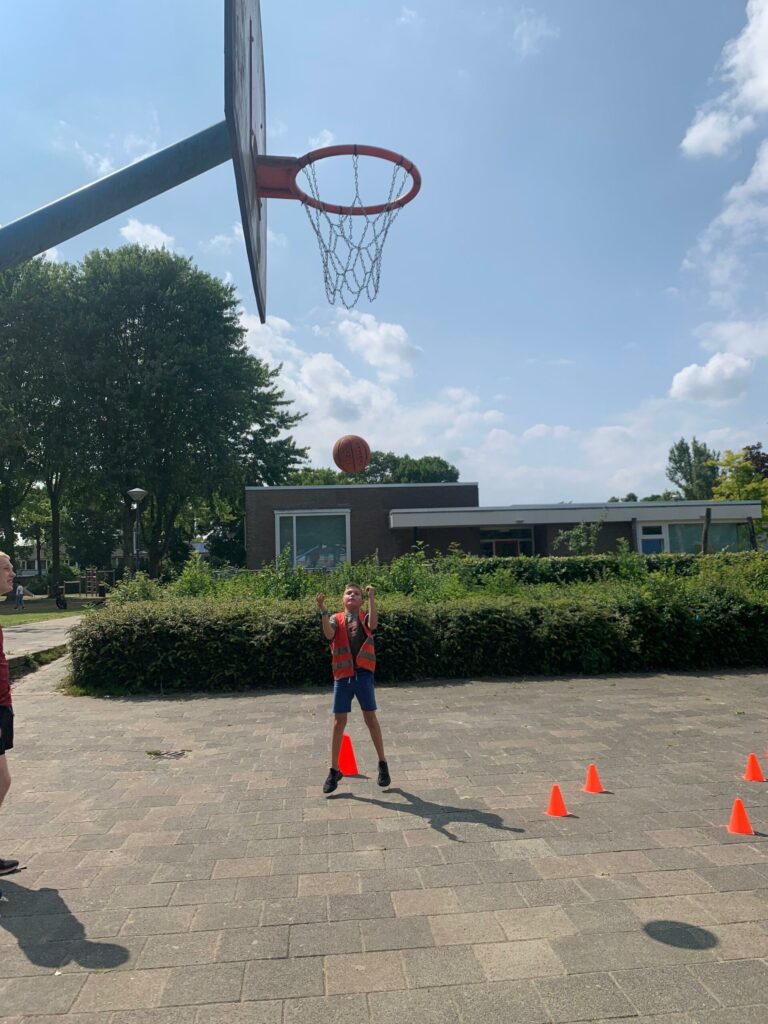 Kinderen basketballen bij Sport-BSO Flekss