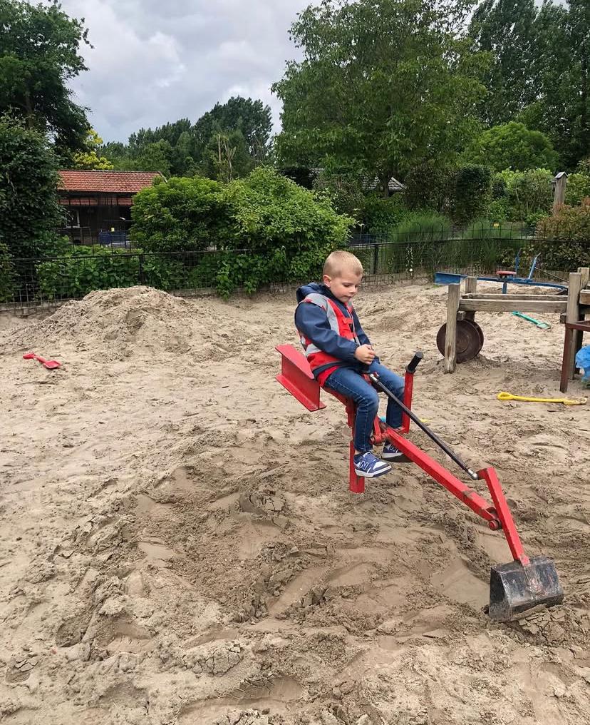 Kind zit op graafmachine bij Sport-BSO Flekss