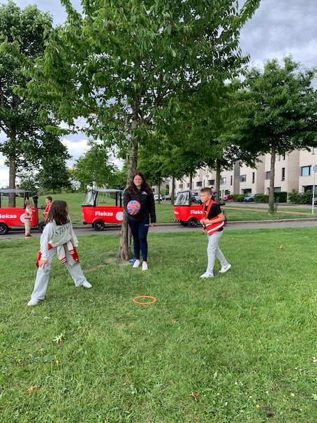 kinderen en juf spelen kickball