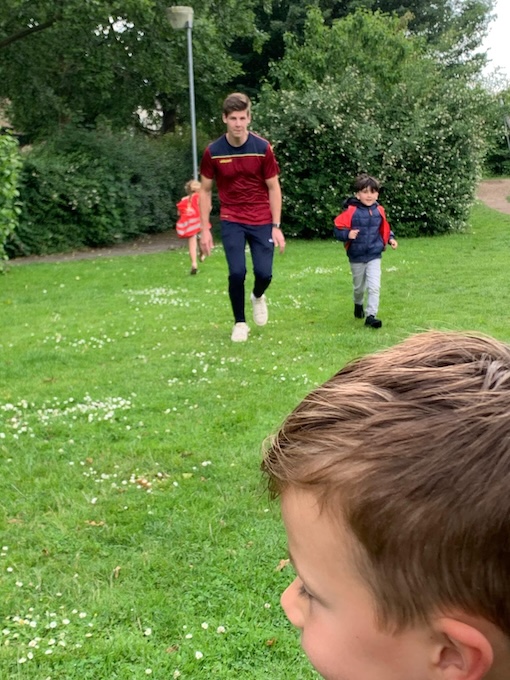 kinderen sporten buiten samen met meester zevenbergen
