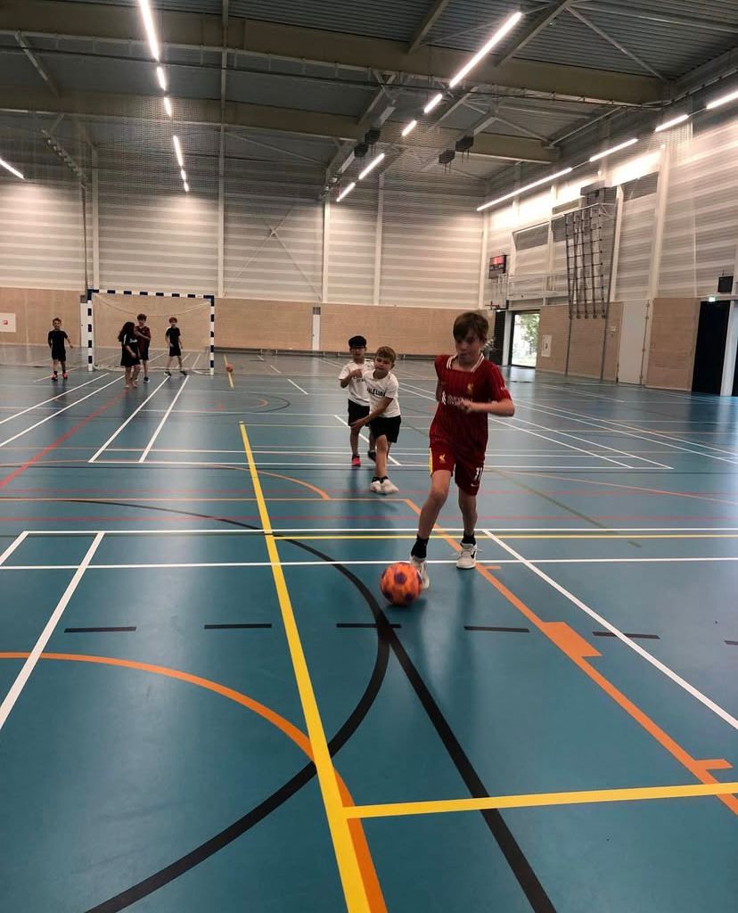 Kinderen voetballen bij Sport-BSO Flekss