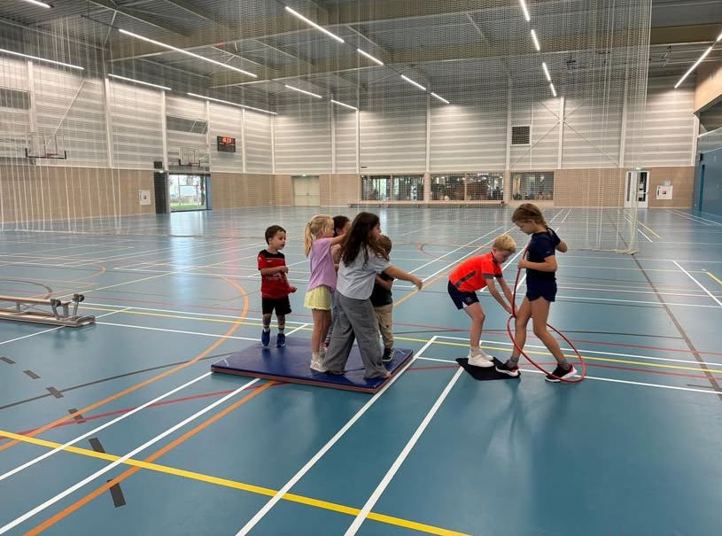 Kinderen werken samen om de overkant te bereiken bij Sport-BSO Flekss