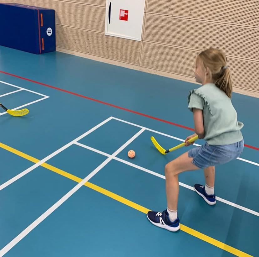 Kinderen hockeyen bij Sport-BSO Flekss
