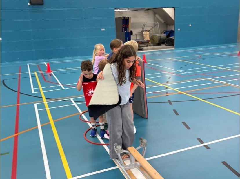 Kinderen werken samen om de overkant te bereiken bij Sport-BSO Flekss